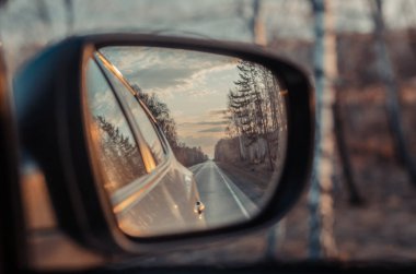 Bir arabanın aynasında yolun yansıması. Yakın plan.