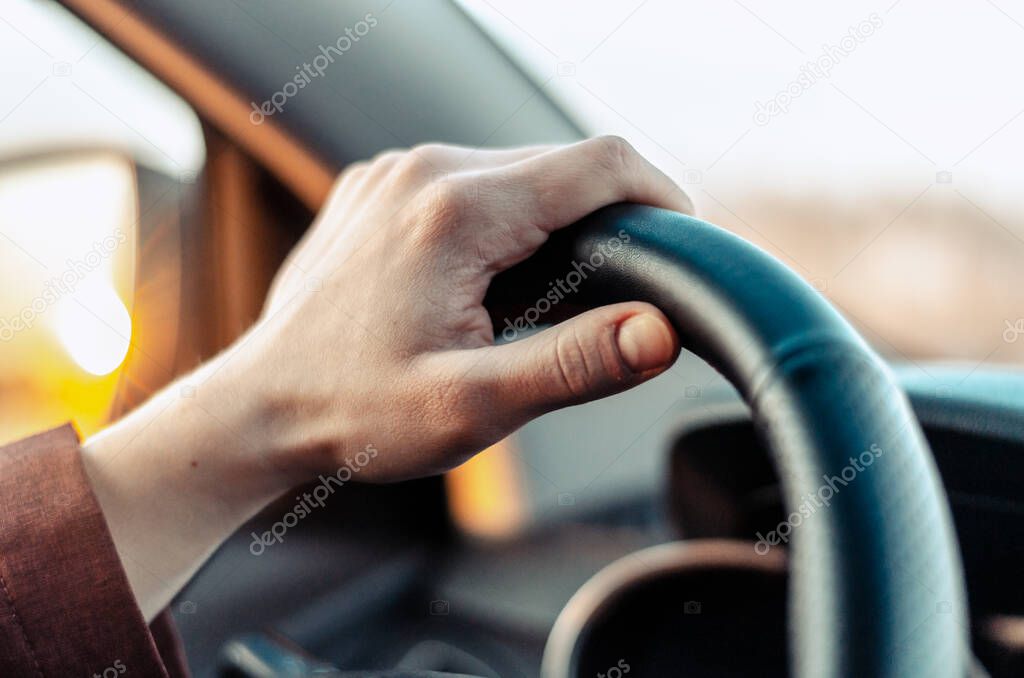 Closeup guy hand on car steering wheel.