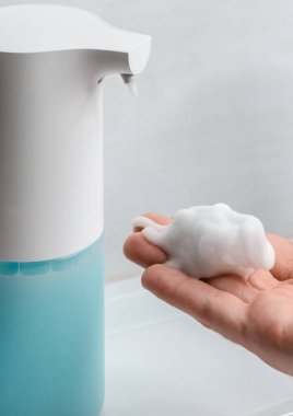 Banyoda otomatik sabun makinesi var. Sabunlu çözeltiye yakın çekim