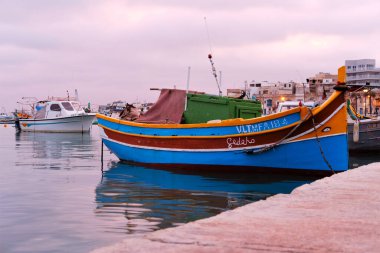 Marsaxlokk 'un geleneksel balıkçı tekneleri, gün batımında Malta