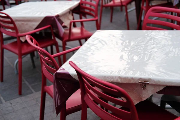 empty restaurant chairs and tables in bad weather in low season.