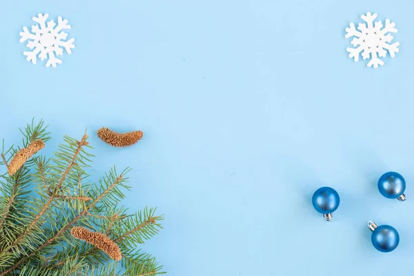 クリスマスと新年の組成物 青い背景に雪片 トウヒの枝と赤い果実 クリスマス 新年のコンセプト フラットポジション トップビュー コピースペース — ストック写真