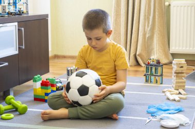 Sağlık maskesi takmış futbol topu. Evde çocuklarınızla birlikte koronavirüs karantinası sırasında evde etkinlikler. Evde kal.