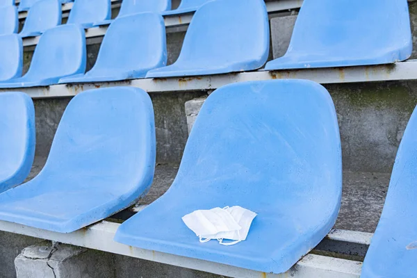 Uma Máscara Médica Está Deitada Numa Cadeira Estádio Estandes Vazios — Fotografia de Stock