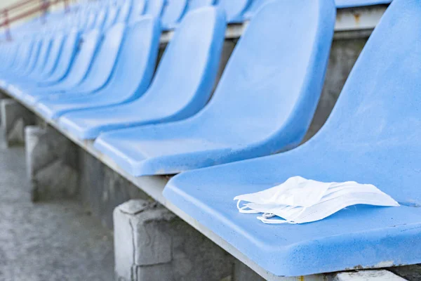 Uma Máscara Médica Está Deitada Numa Cadeira Estádio Estandes Vazios — Fotografia de Stock