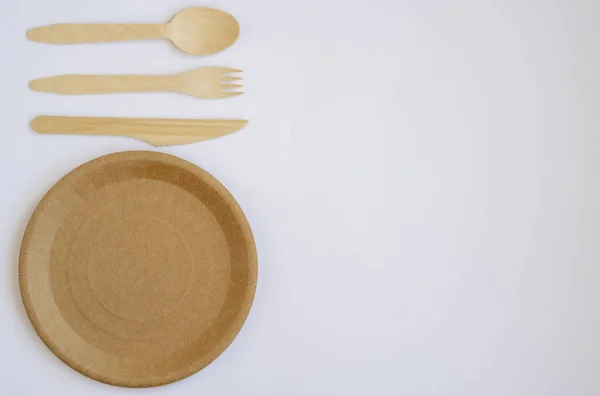 环保餐具用于食品和木制Eco刀 勺子上的轻背景和一个复制空间 Eco Food Packaging Made Recycled Kraft Paper 有利于经合组织的野餐盘 — 图库照片