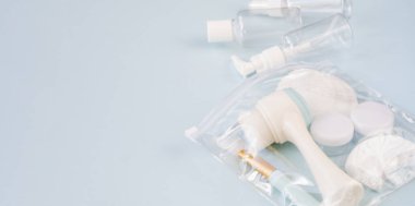 Plastik kaplar. Mavi arka planda seyahat ayarlandı. Krem, şampuan, lens kapları ve kapalı bir çantada diş ipi için plastik şişeler. Üst görünüm, boşluk kopyala