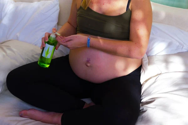 배에 크림을 바르는 무료 상표권을 가진 임신 한 알로에 베라 보트 스톡 사진