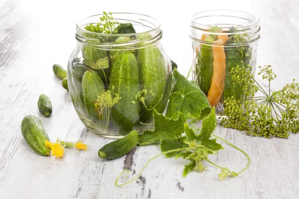 Färsk saltgurka i glas på vitt trä bord. — Stockfoto