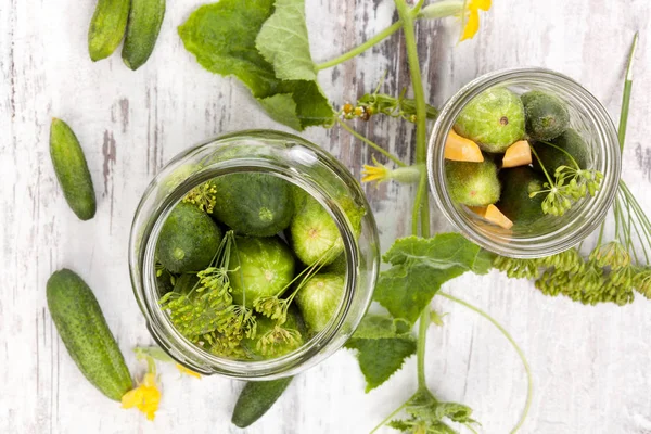 Färsk saltgurka i glas på vitt trä bord — Stockfoto