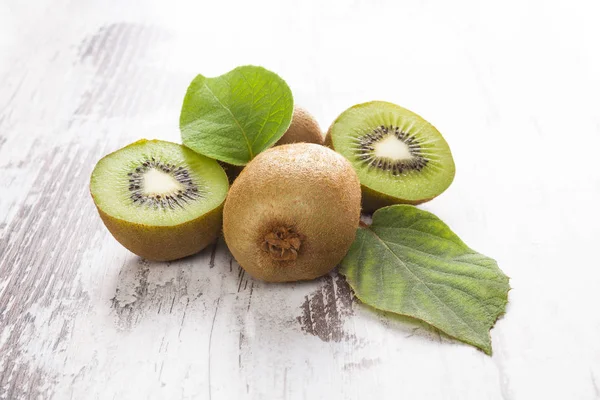 Kiwi-Früchte auf weißem Holztisch. — Stockfoto