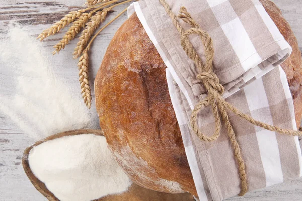 Chleb z mąką na drewnianym stole — Zdjęcie stockowe