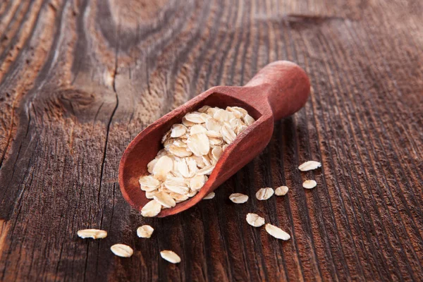 Haferflocken auf Holztisch. — Stockfoto