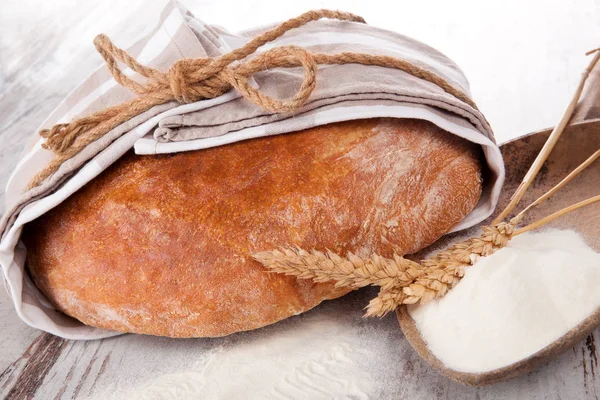 Bread with flour on wooden table — Stock Photo, Image