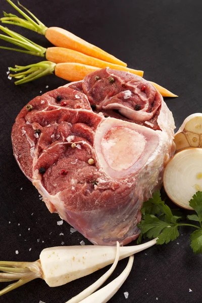 Raw ossobuco steak with fresh vegetables. — Stock Photo, Image