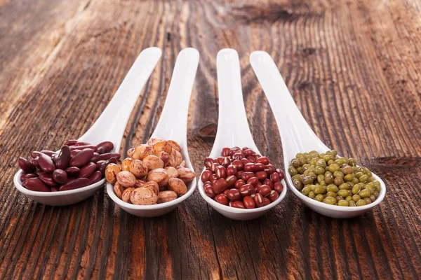 Fresh legumes in spoons — Stock Photo, Image