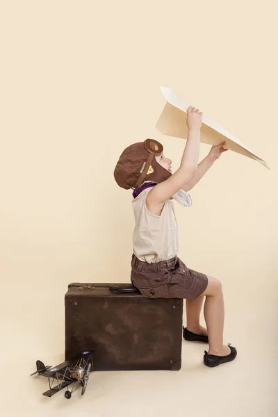 Jong meisje speelt met vintage papieren vliegtuigje — Stockfoto