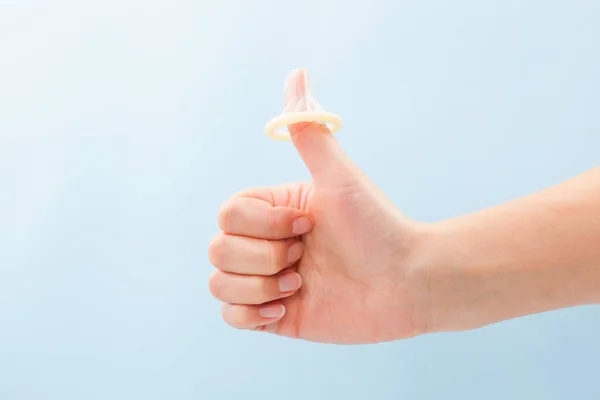 Thumbs up with condom on thumb. — Stock Photo, Image