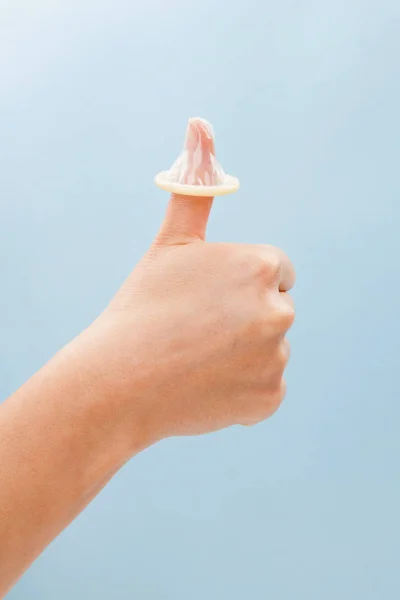 Thumbs up with condom on thumb. — Stock Photo, Image