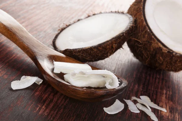 Kokosöl in Löffel auf Holztisch. — Stockfoto
