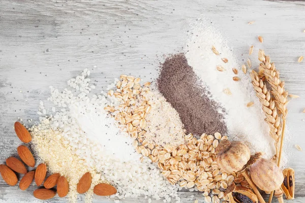 Różne rodzaje mąki na drewnianym stole — Zdjęcie stockowe