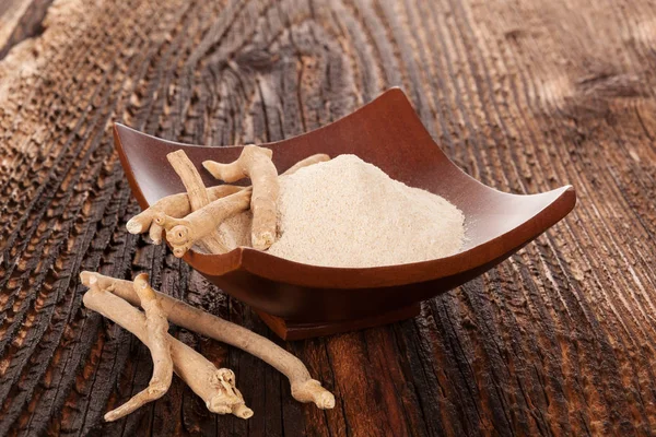 Ashwagandha-Pulver in Schüssel mit Wurzeln — Stockfoto