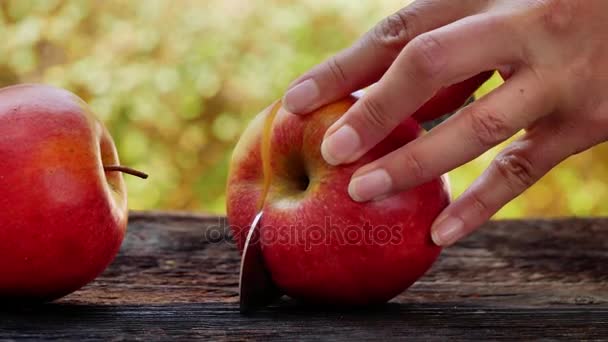 Frau Schneidet Roten Apfel Mit Einem Scharfen Messer Auf Holzbrett — Stockvideo