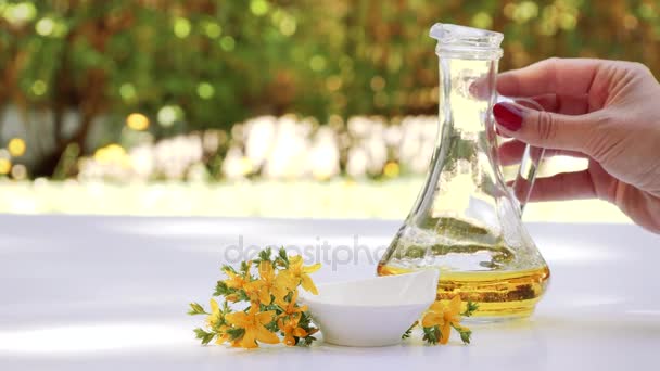 屋外のテーブルに受け皿にセントジョーンズワート油を注ぐ 健康的な自然療法 — ストック動画