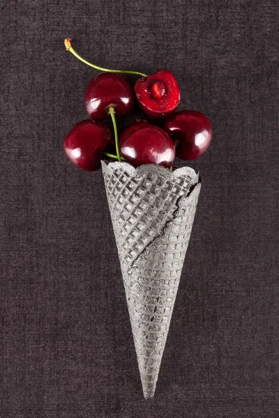 Cono de helado negro con cerezas frescas — Foto de Stock