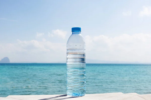 Butelka wody na tropikalnej plaży. — Zdjęcie stockowe