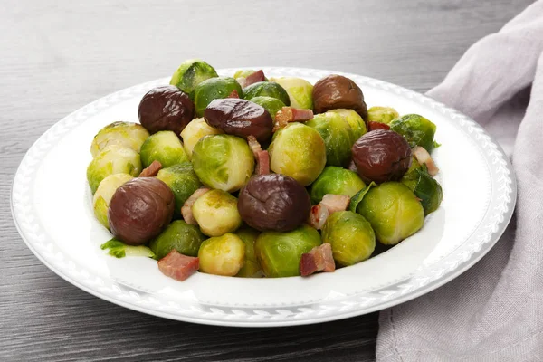 Roasted brussels sprouts with bacon and chestnuts — Stock Photo, Image