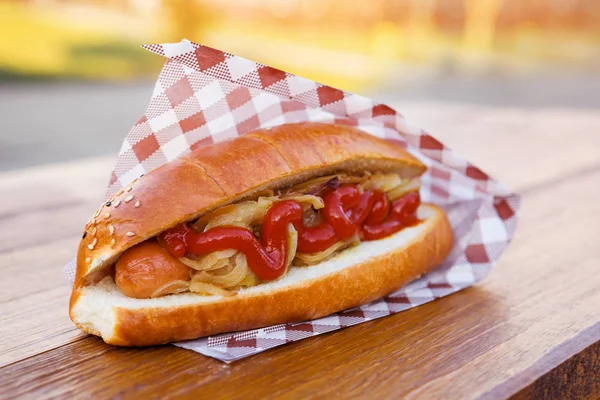 Americký hot dog sendvič s klobásou, cibulí a omáčkou. — Stock fotografie