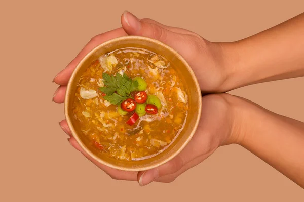 Mujer sosteniendo sopa caliente y agria en eco taza . — Foto de Stock