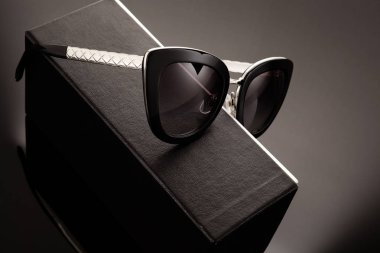 Siyah bir kutuda modaya uygun güneş gözlüğü. Asgari düzeyde. Minimalist moda fotoğrafı.