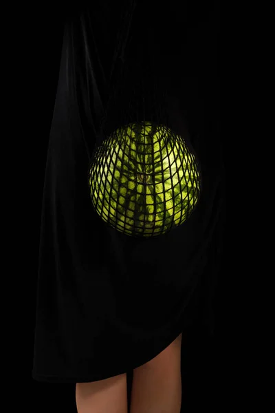优雅优雅优雅的女人 西瓜在一个生态友好的可重复使用的网袋 奢侈的 素食的 现代的 可持续的生活方式 黑色在黑色 — 图库照片