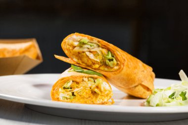 Tortilla, körili tavuk ve sebzeli beyaz tabağa sarılmış. Tavuk dürüm. Sağlıklı yemek..