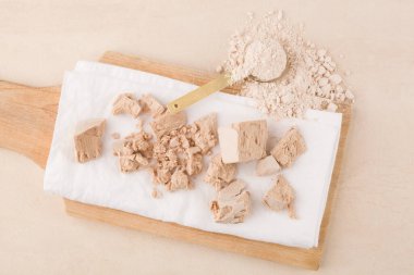 Hamur işi. Bej arkaplanda tahta üzerinde maya kalıpları ve un.