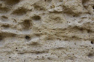 Kum rengi doğal taş duvar. Yakın çekim görünümü.