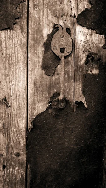 Puerta vieja con una manija de puerta rara fondo de escala de grises — Foto de Stock