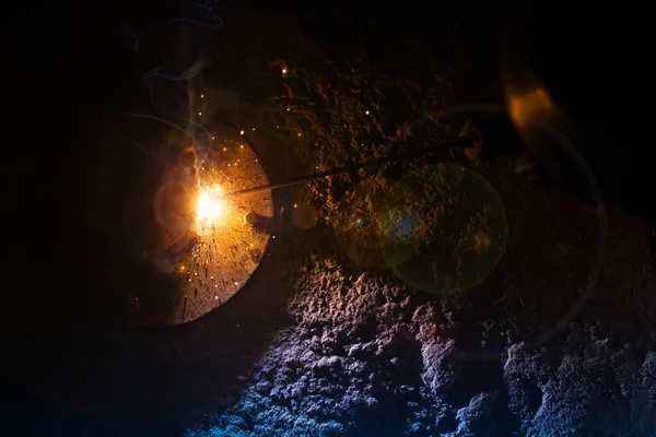 siyah arka plan üzerine bir elektrot ile metal kaynak işlemi