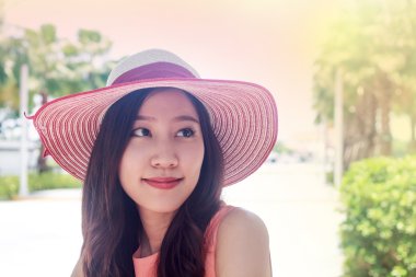 mutlu ifade ile pembe hasır şapka giyen kadın