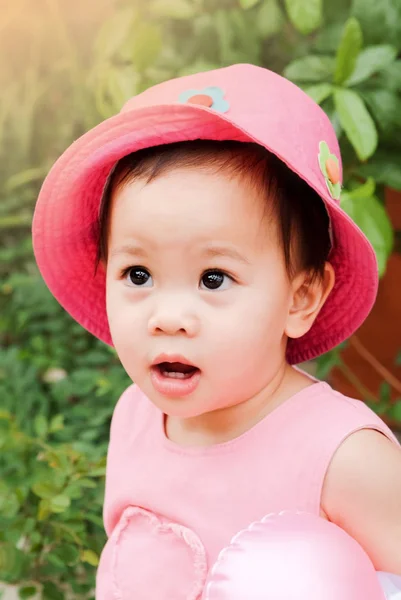 Азиатская маленькая девочка в розовой шляпе и платье — стоковое фото