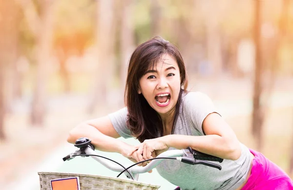 Mature woman ride bicycle and expression of surprise — Stock Photo, Image