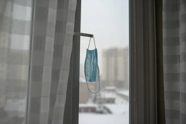 Medical mask hanging on the window