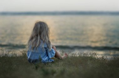 People at the seashore look at the boat