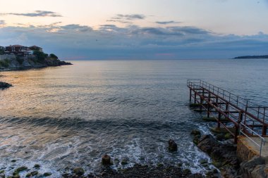 People at the seashore look at the boat