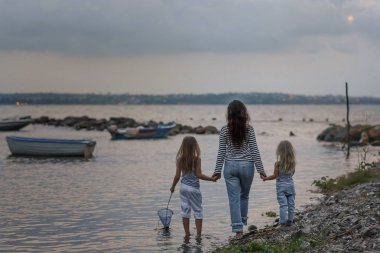 People at the seashore look at the boat