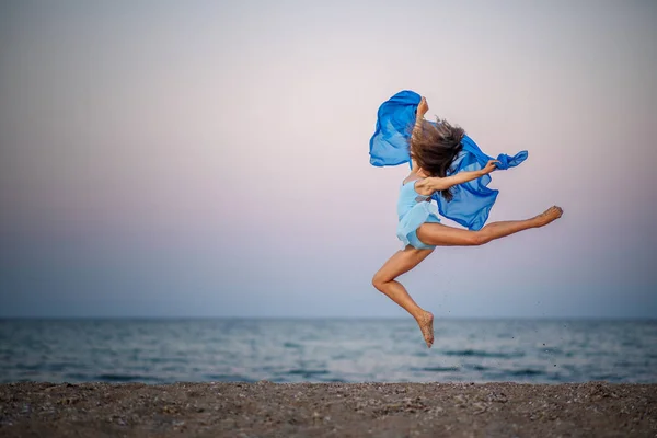 ballerina in a jump by the sea