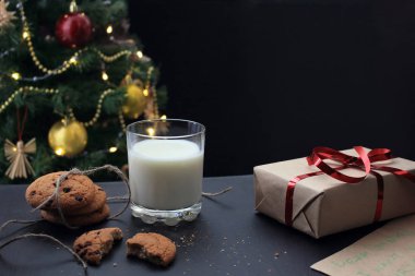 Bir bardak süt, çikolatalı kurabiyeler ve kırıntılar.