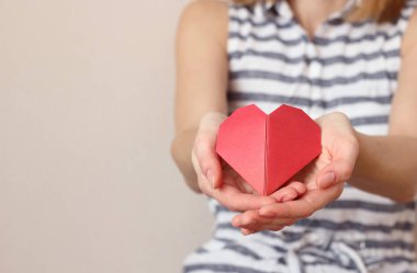 Kafkasyalı kadın ellerini kalp şeklinde katlıyor ve elini tutuyor.